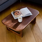 Wooden coffee table with a magazine and cup on a wooden floor